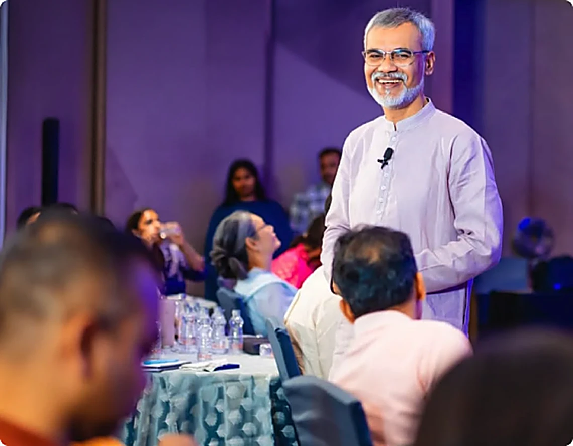 Vibhushri smiling while speaking to a seated audience