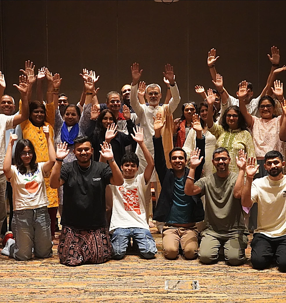 Group of Wellness Vibe workshop participants raising hands together