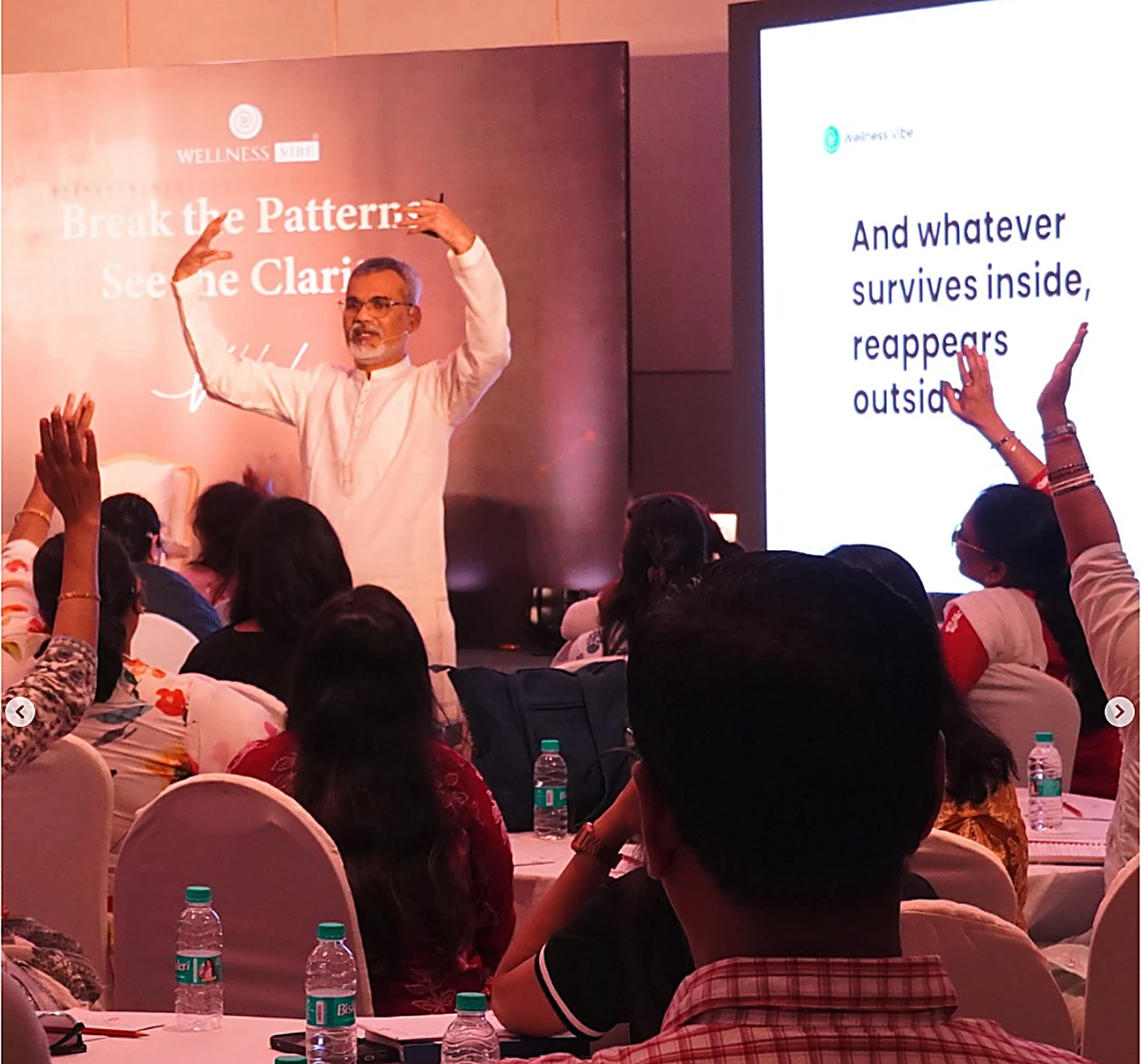 Vibhushri teaching with hands raised in front of a presentation slide